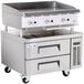 A stainless steel Cooking Performance Group gas countertop griddle with refrigerated chef base drawers.
