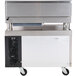A Cooking Performance Group gas countertop griddle with a refrigerated chef base on wheels with a black and silver surface.