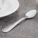 A Walco stainless steel demitasse spoon on a table.