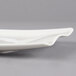 A white Villeroy & Boch rectangular platter with a curved edge on a gray surface.