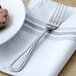 A Walco stainless steel dinner fork on a napkin.