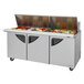 A Turbo Air stainless steel refrigerated sandwich prep table with three trays of food.