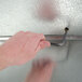 A hand using a key to unlock a Norlake Kold Locker walk-in freezer.