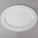 A white Thunder Group oval melamine platter with a white rim on a gray surface.