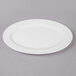A white Thunder Group oval melamine platter with a white rim on a gray surface.