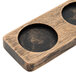 A wooden tray with two small holes for glasses on a table.