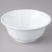 A white bowl with a scalloped rim on a gray surface.