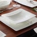 A Villeroy & Boch white bone porcelain deep plate with a spoon on it on a table.