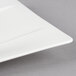 A close-up of a Villeroy & Boch white bone porcelain rectangular plate with a small cut out in the middle.