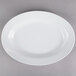 A white Thunder Group oval melamine platter with a rim on a gray surface.