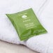 A green package of Basic Earth Botanicals bath soap on a white towel.