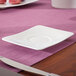 A white Villeroy & Boch Modern Grace bone porcelain saucer on a purple surface.
