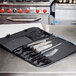 A Mercer Culinary Genesis 10 piece knife set in a black case on a counter.
