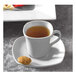 A Bright White porcelain square cup filled with tea on a plate with a small cookie.