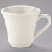 A Tuxton eggshell white china tall cup with an embossed rim and handle.