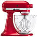 A KitchenAid candy apple red stand mixer with a glass bowl.