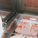 A tray of meat and vegetables in a Turbo Air sandwich prep refrigerator.