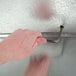 A hand using a metal key to unlock a Norlake Kold Locker walk-in freezer.