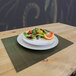 A plate of salad on a H. Risch green and brown woven vinyl rectangle placemat.