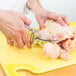 Victorinox Heavy Duty Stainless Steel Poultry Shears cutting a chicken on a yellow cutting board.