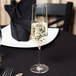 A Stolzle flute of champagne on a table.