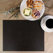 A customizable black faux leather rectangle placemat with a plate of pastries and a cup of coffee on it.