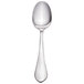 A close-up of a Walco stainless steel dessert spoon with a white handle.