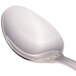A close-up of a Walco stainless steel teaspoon with a silver handle.