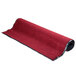 A rolled up red Cactus Mat carpet with black trim.