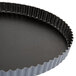 A black Matfer Bourgeat fluted quiche pan with a metal rim.