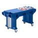 A blue plastic Cambro Versa work table with standard casters holding a blue plastic bin with bottles in it.