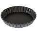 A black fluted tart pan with a removable bottom.