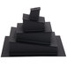 A stack of black Matfer Bourgeat cake inserts on a table.