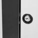 A close-up of the black rectangular door lock on a white surface with a keyhole.