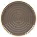 A brown stoneware plate with a white ripple design around the rim.