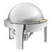 A stainless steel round chafer with gold accents and a roll top lid.