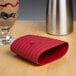 A red iSi heat protection sleeve on a table.