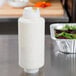 A white FIFO Innovations squeeze bottle filled with white liquid and a white lid on a counter.