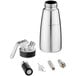 A close-up of a silver stainless steel iSi whipped cream dispenser with white accessories.