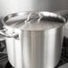A large silver stainless steel lid on a large stainless steel pot.