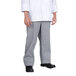 A person wearing a white chef coat and Chef Revival houndstooth pants.