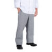A person wearing a white shirt and grey houndstooth Chef Revival pants.