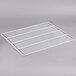A white coated wire bottom shelf for a deli or bakery case.