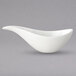 A white gravy boat with a curved handle.