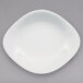 A white porcelain oval plate with a small rim on a gray background.