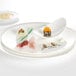 A Villeroy & Boch white bone porcelain coupe plate with food on it.