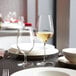 A table with Chef & Sommelier wine glasses and plates set for a meal.