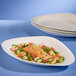 A Villeroy & Boch white porcelain oval plate with salmon and vegetables on a table.