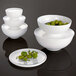 A stack of white Villeroy & Boch bowls with a bowl of olives on top.