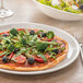 A Villeroy & Boch white porcelain plate with a pizza and salad on it.